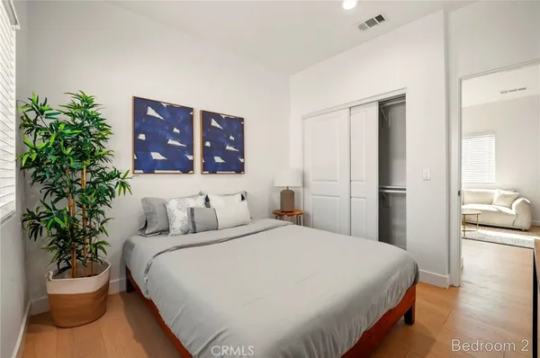 a bedroom with a bed and a potted plant
