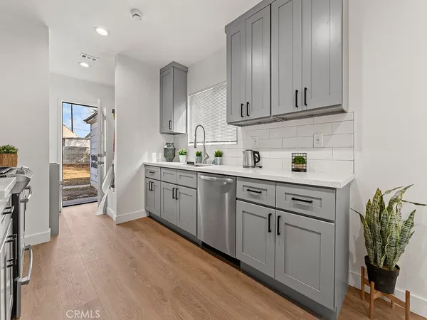 a kitchen with stainless steel appliances dining table chairs and wooden floor