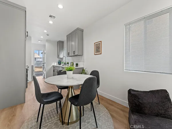 a living room with furniture and a dining table with wooden floor