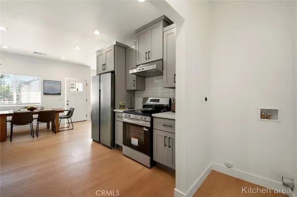 a kitchen with stainless steel appliances granite countertop a refrigerator stove oven and white cabinets