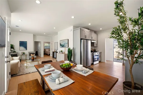 a living room with furniture a refrigerator and a tree