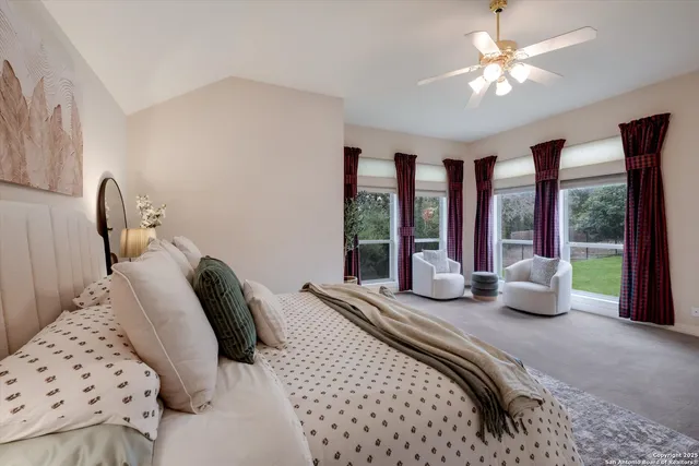 a bedroom with furniture and a large window