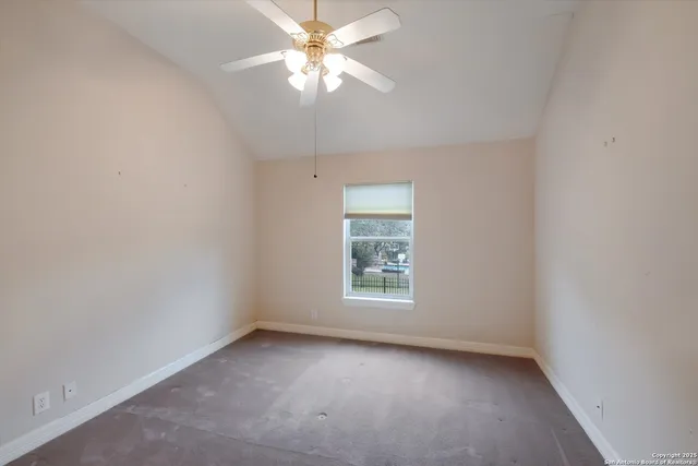an empty room with a window and a fan