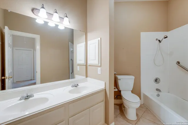 a bathroom with a toilet a sink a tub and a mirror