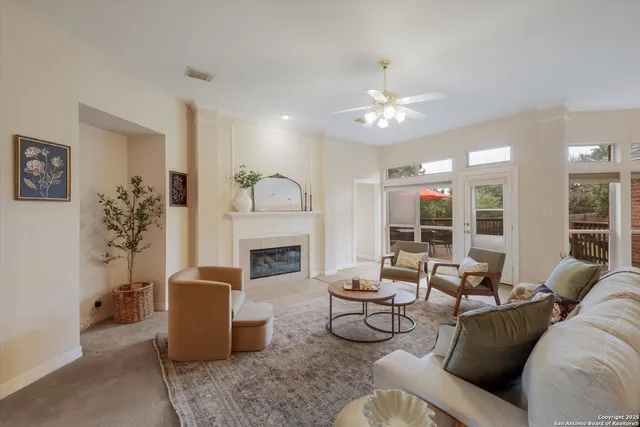 a living room with furniture a fireplace and a chandelier