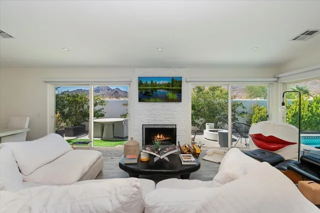 a living room with furniture fireplace and a large window