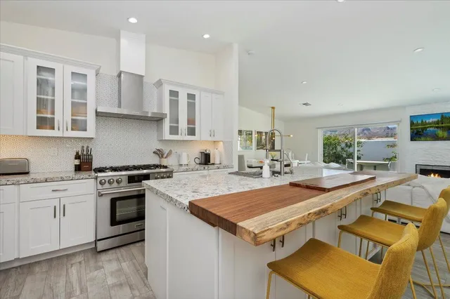 a kitchen with a stove a sink dishwasher and a refrigerator with wooden floor