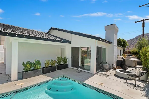 a view of a house with backyard sitting area and garden