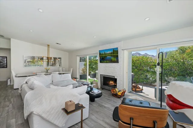 a living room with furniture fireplace and a large window