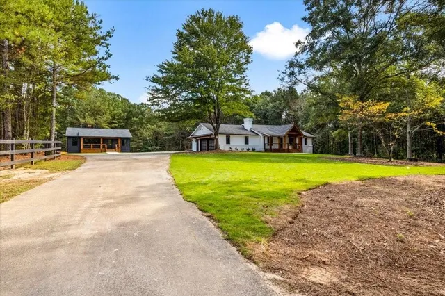 a view of a swimming pool with a lawn chairs and a big yard