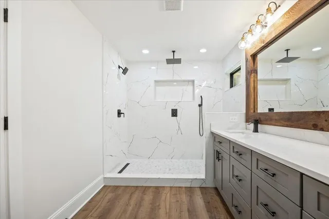 a bathroom with a granite countertop sink a toilet and shower