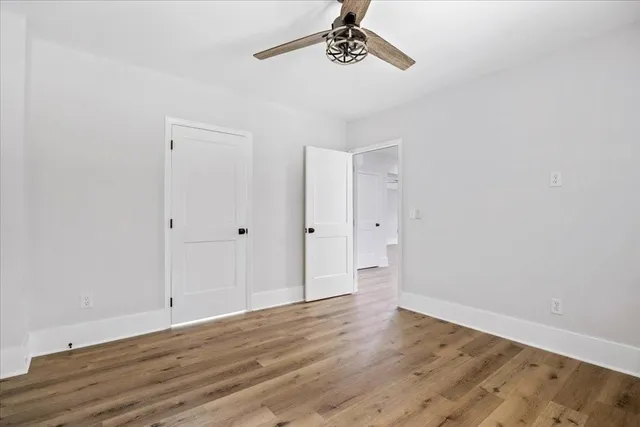 a view of a hallway with wooden floor and staircase