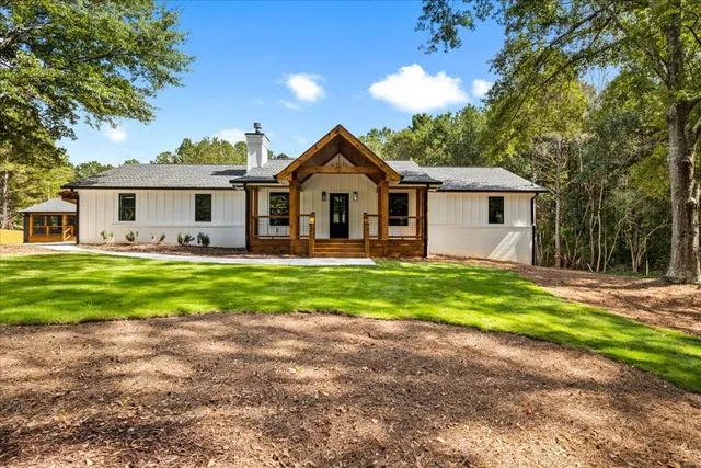 a view of a house with pool and a yard