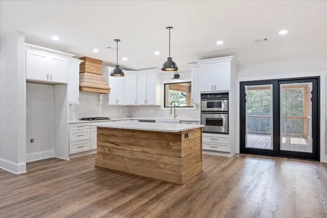 a kitchen with kitchen island a sink stainless steel appliances and cabinets
