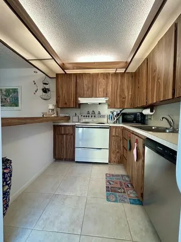 a kitchen with stainless steel appliances granite countertop a stove sink and cabinets