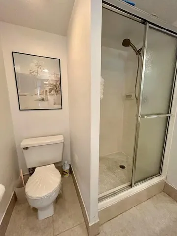 a bathroom with a toilet and a shower
