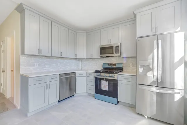 a kitchen with cabinets stainless steel appliances and a refrigerator