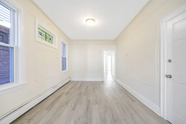 a view of room with window and wooden floor