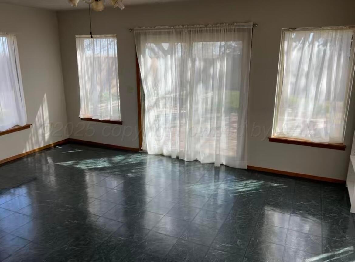 613 South Fulton Street Stratford, TX 79084 - Photo 5 of 15 a view of an empty room with wooden floor and a window