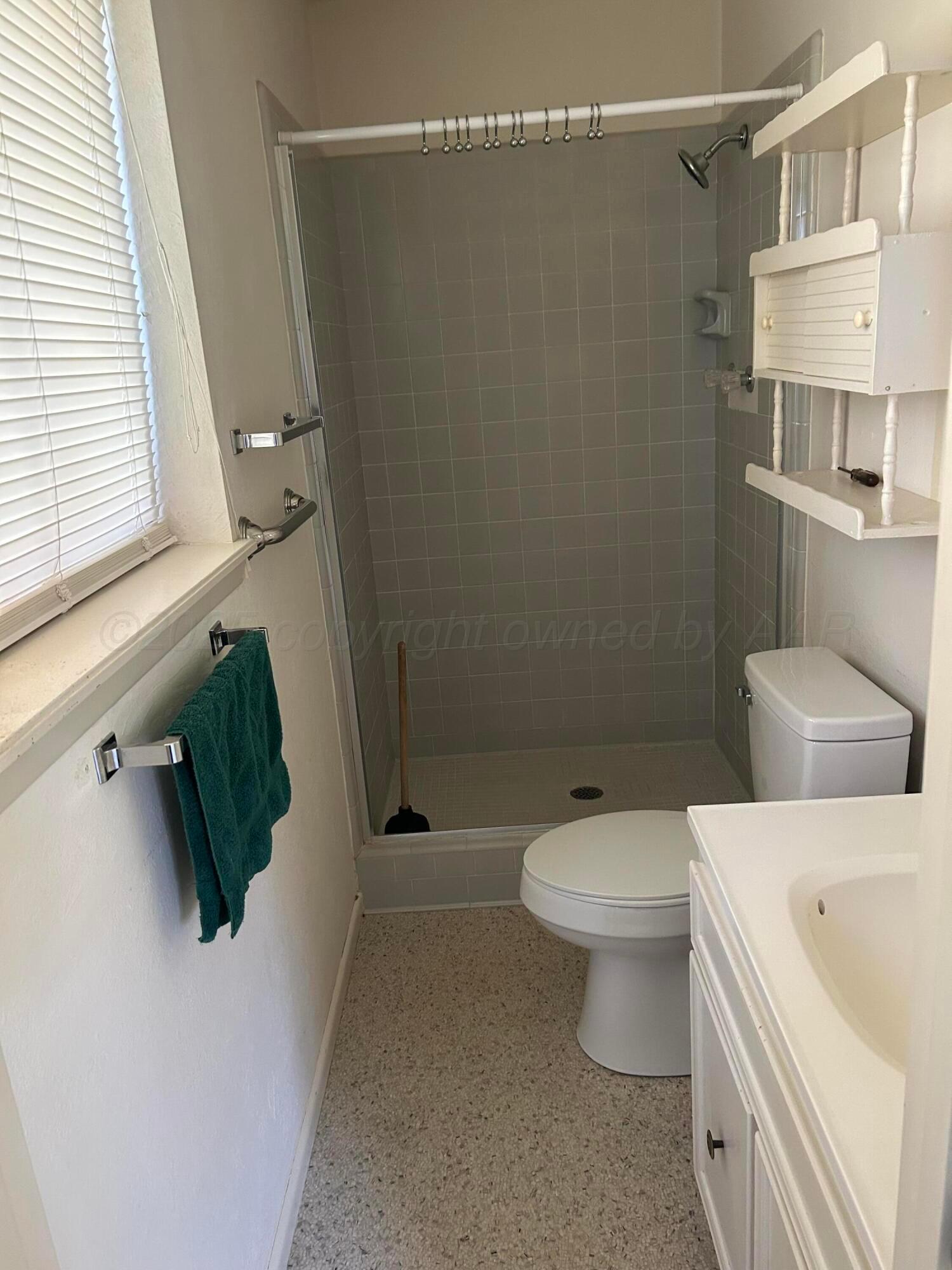 613 South Fulton Street Stratford, TX 79084 - Photo 9 of 15 a white toilet sitting next to a bathroom sink