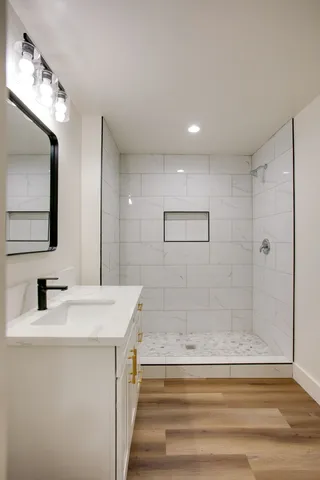 a bathroom with a sink a shower and a mirror