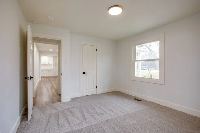 an empty room with windows and closet