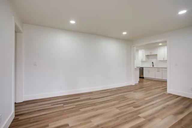a view of empty room with wooden floor