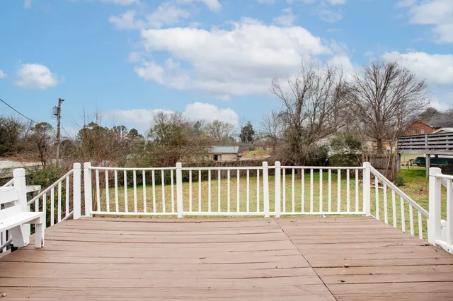 a view of balcony with wooden floor and fence