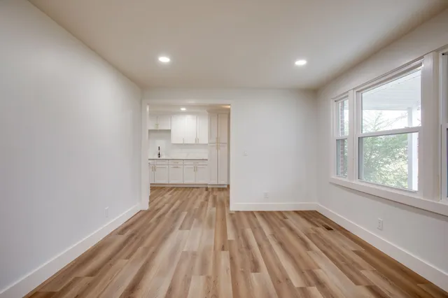 a view of a room with wooden floor and windows