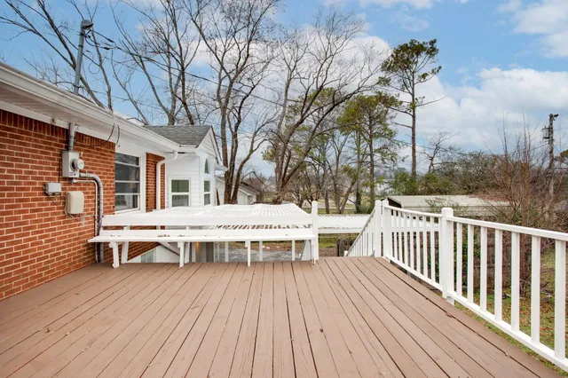 a roof deck with table and chairs a barbeque with wooden floor and fence