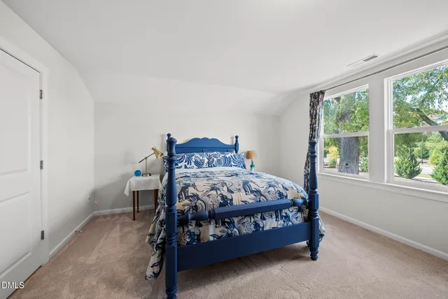 a bedroom with a bed that has a blanket on it and next to a window