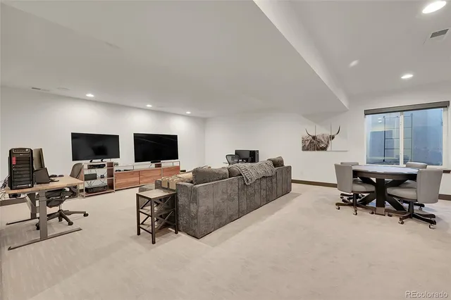 a living room with furniture a flat screen tv and a window