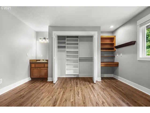 a view of empty room with wooden floor and cabinet