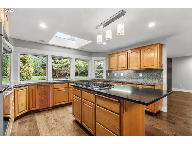 a kitchen with stainless steel appliances granite countertop sink stove and cabinets
