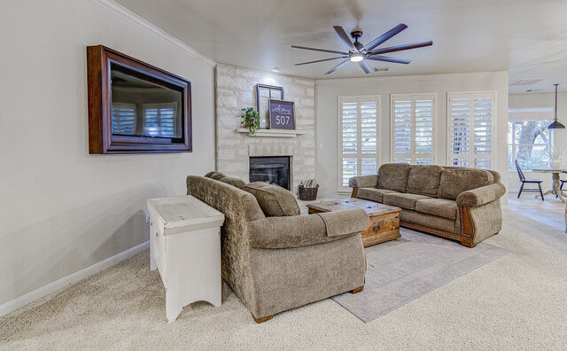 507 Rummel Ranch Run Cedar Park, TX 78613 - Photo 15 of 39 A comforting living room offers a stone-framed fireplace and ceiling fan, perfect for relaxation.