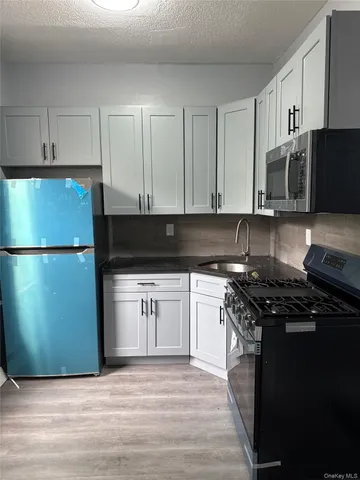 a kitchen with granite countertop a refrigerator stove top oven and sink