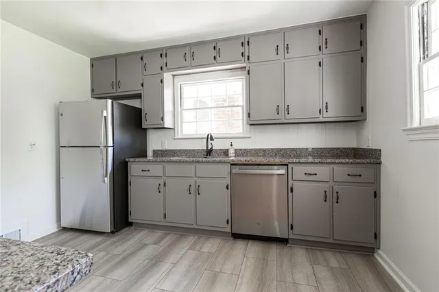 a kitchen with granite countertop cabinets appliances and a window