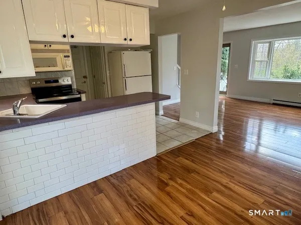 a kitchen with granite countertop wooden cabinets a sink and dishwasher