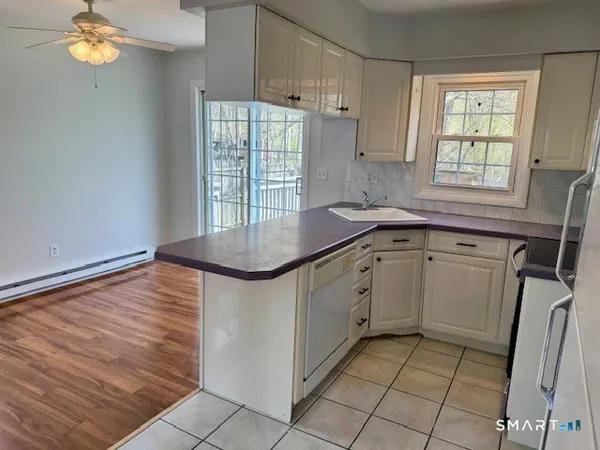 a kitchen with granite countertop a sink window and cabinets