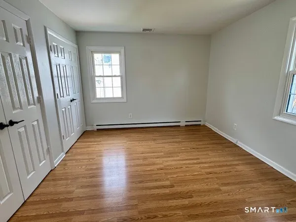 a view of a room with wooden floor and window