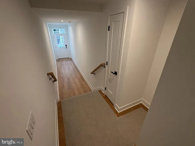 a view of a hallway with wooden floor and staircase