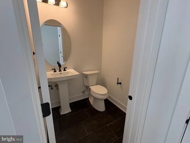 a bathroom with a toilet a sink and a mirror