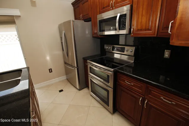a kitchen with granite countertop a refrigerator and a stove