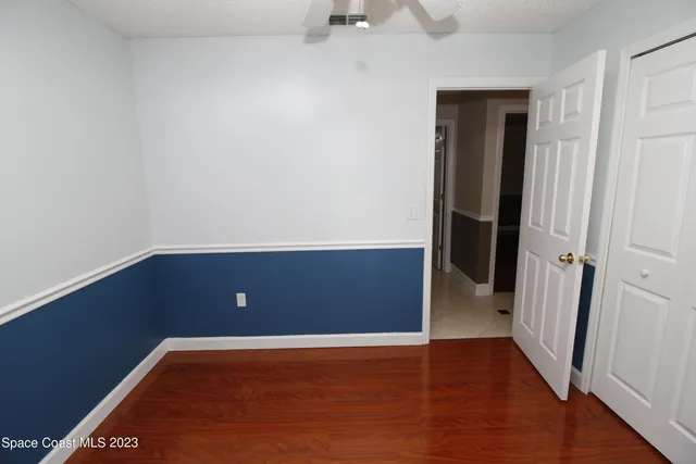 an empty room with wooden floor and entrance