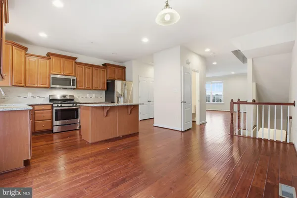 a kitchen with stainless steel appliances granite countertop a stove top oven a sink and a refrigerator