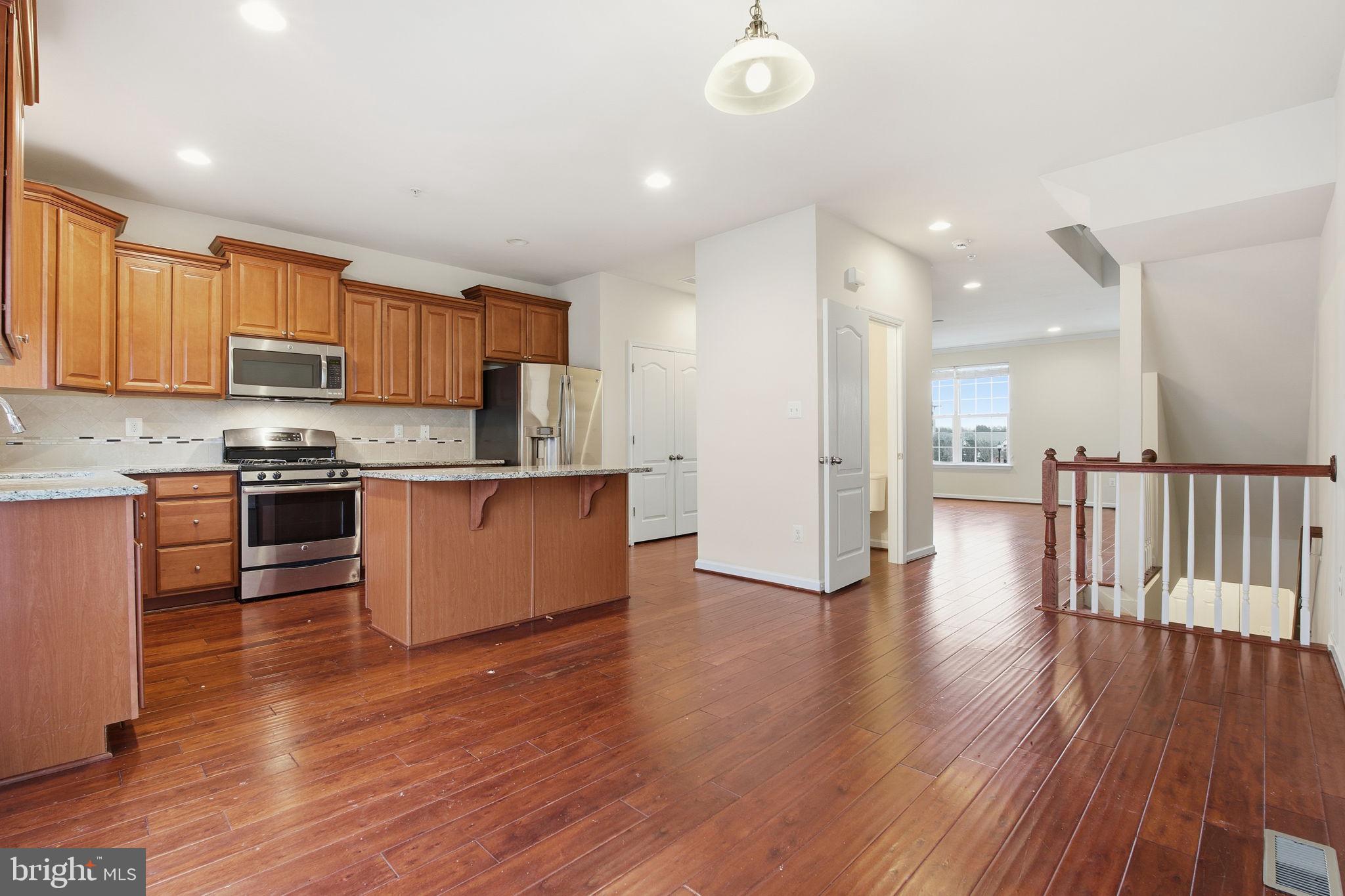 7025 Southmoor Street Hanover, MD 21076 - Photo 11 of 35 a kitchen with stainless steel appliances granite countertop a stove top oven a sink and a refrigerator
