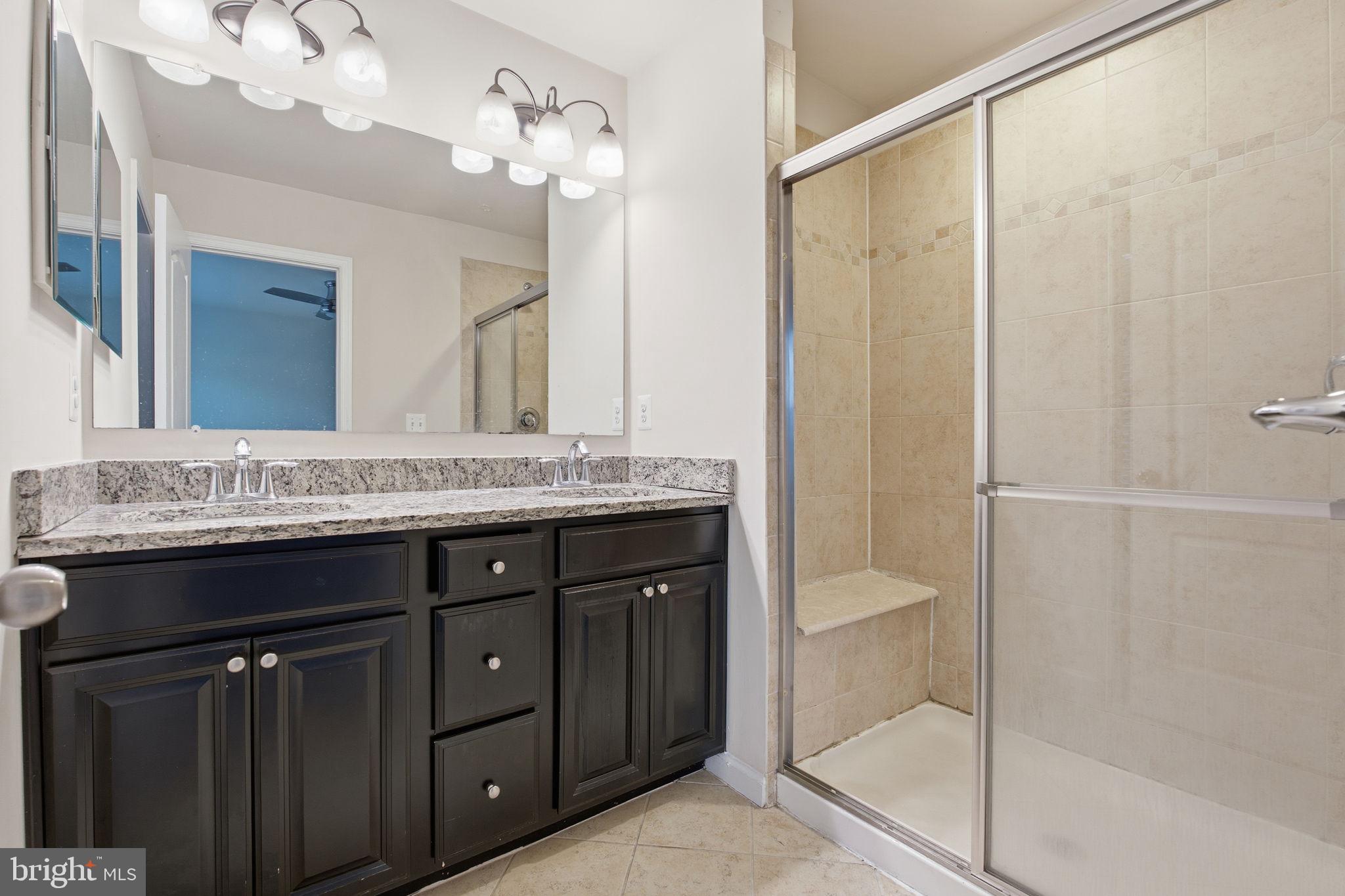 7025 Southmoor Street Hanover, MD 21076 - Photo 23 of 35 a bathroom with a granite countertop sink a toilet and shower