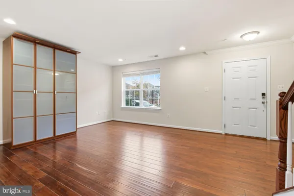 an empty room with wooden floor and windows