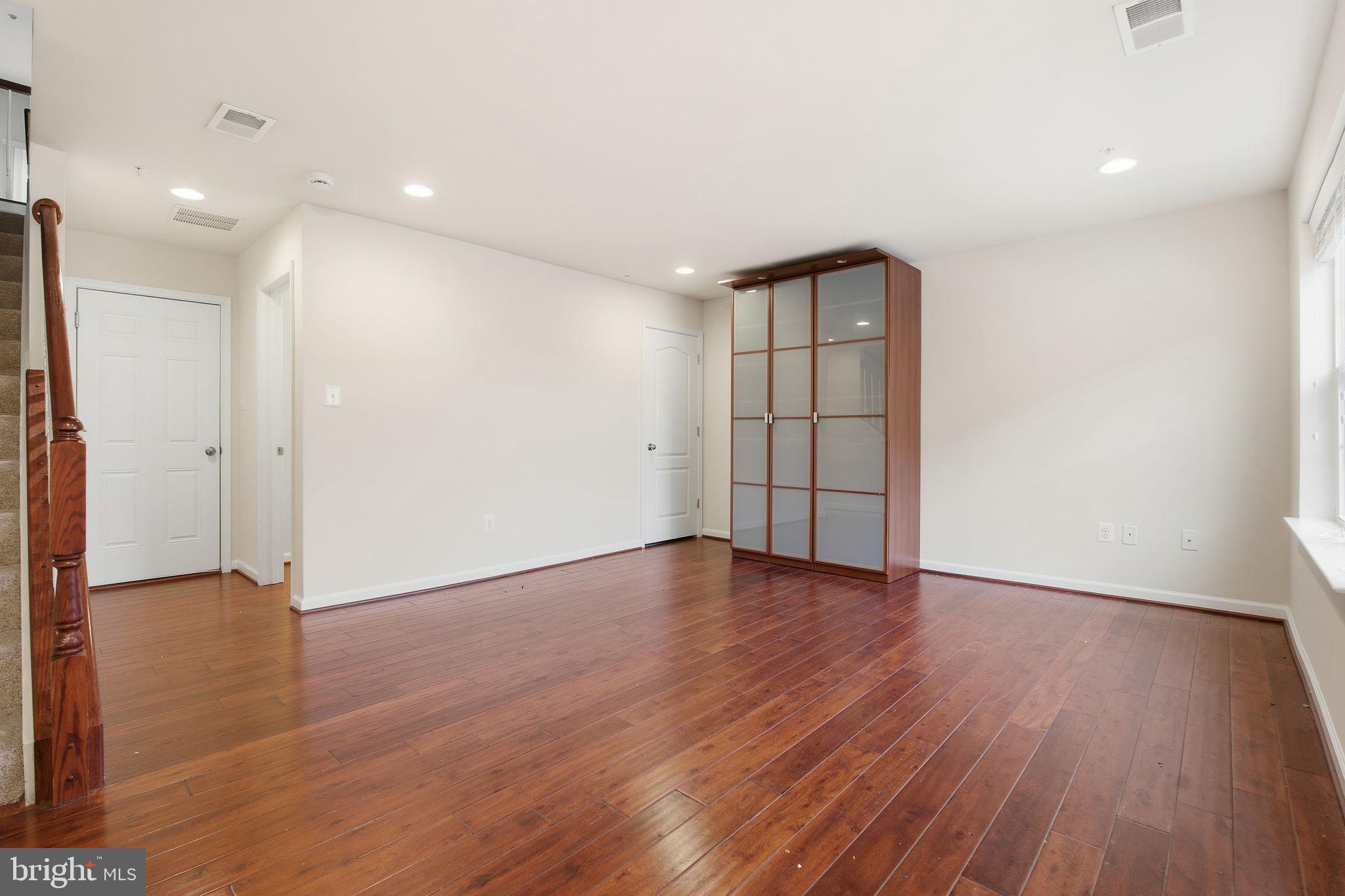 7025 Southmoor Street Hanover, MD 21076 - Photo 4 of 35 a view of an empty room with wooden floor and a window