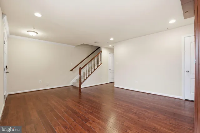 a view of an empty room with wooden floor